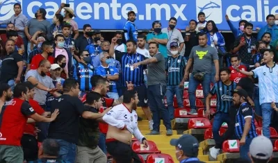 Aficionados de Querétaro y Atlas se enfrentaron al minuto 62 del partido, en el estadio Corregidora de la ciudad de Querétaro (México).