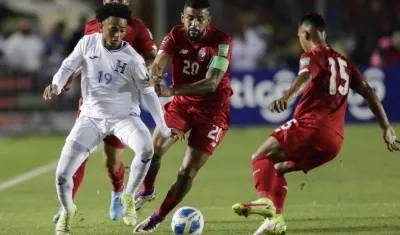 Aníbal Godoy (c) de Panamá disputa un balón con Cristian Sacaza de Honduras .
