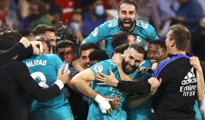 Karim Benzema felicitado por sus compañeros tras anotar ante el Sevilla.