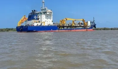 La draga china trabajando en el canal de acceso.