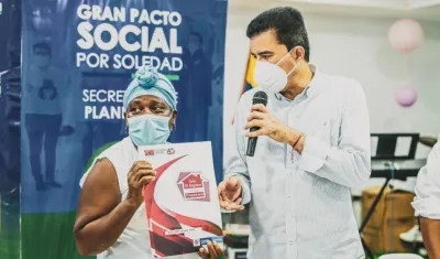 El alcalde Rodolfo Ucrós entregando un título de propiedad a una de las familias beneficiadas. 