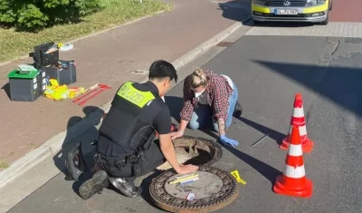 Policía sellando la alcantarilla. 