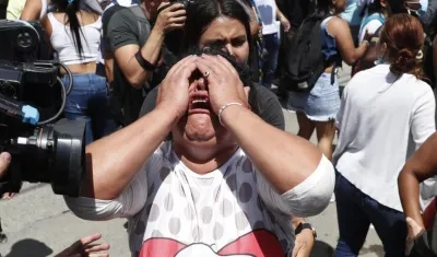 Una mujer llora mientras familiares y amigos de reclusos intentan saber el estado de salud de los detenidos de la cárcelde Tuluá.