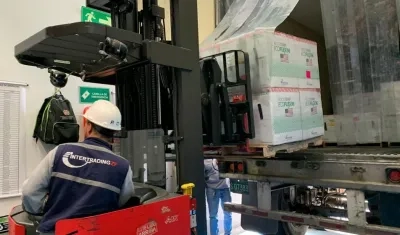 Un operario baja cajas que contienen vacunas Janssen enviadas por EE.UU.