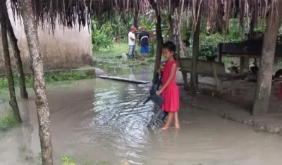 Una niña sucreña camina entre las aguas desbordadas y estancadas.