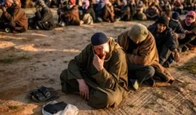 Foto captada en 2019 cuando hombres sospechosos de ser combatientes del Estado Islámico (EI) esperan a ser registrados por miembros de las Fuerzas Democráticas Sirias 