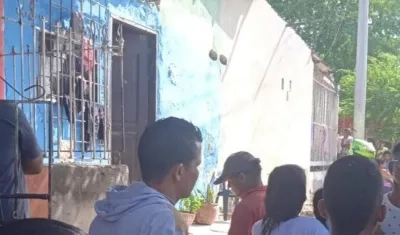 Curiosos se reúnen en el frente de la vivienda en la que fueron asesinadas dos mujeres.