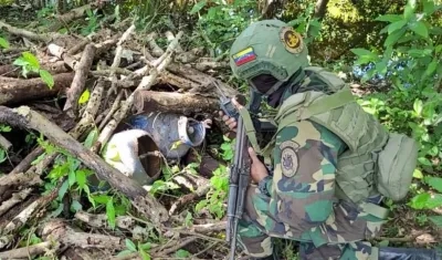 Un militar venezolano revisa material explosivo hallado en el Estado Apure.