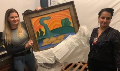 Dos agentes de policía mientras sostienen el cuadro 'Sol poente'.