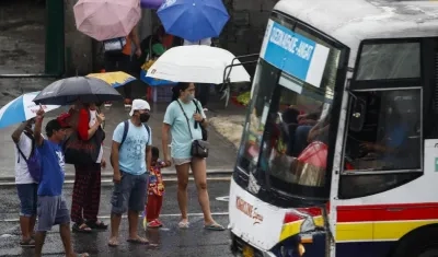 Ciudadanos de protegen de las lluvias con paraguas.