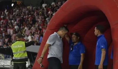Juan Cruz Real, entrenador de Junior, se marcha al camerino con la escultura del Cristo Negro, bajo los insultos de los hinchas. 