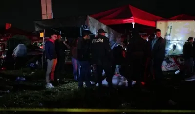 Policías vigilan los cuerpos de las víctimas de estampida humana en Quetzaltenango, Guatemala.