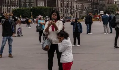Una mujer se arrodilla en pleno centro de Ciudad de México durante el sismo de este lunes.