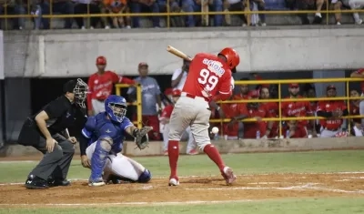 Roberto Caro, de Tigres, recibe pelotazo del lanzador Fernando Pérez, de Vaqueros. 