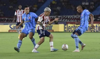 Juan Fernando Quintero intentando eludir a dos visitantes.