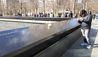 Un grupo de personas verificando las placas de las víctimas.