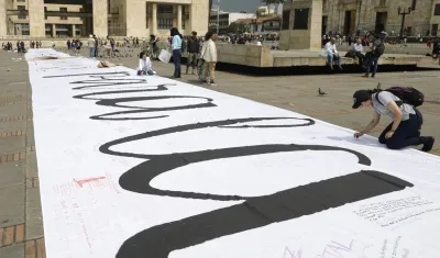 Imagen de referencia de personas que escribieron mensajes sobre una tela durante la conmemoración de los seis años de la firma del Acuerdo de Paz.