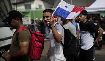 Migrantes de origen venezolano hacen fila para subir a un autobús hacia el aeropuerto internacional de Tocumen en Ciudad de Panamá.
