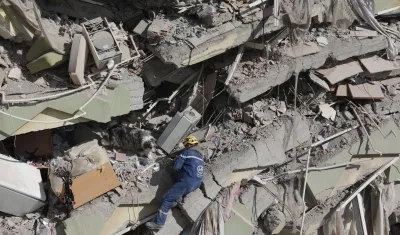 Un rescatista francés y su perro de búsqueda, trabajan para hallar supervivientes entre los escombros de un edificio derrumbado en Kahramanmaras, Turquía