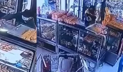 Momento en que uno de los presuntos delincuentes disparó contra la panadería. 