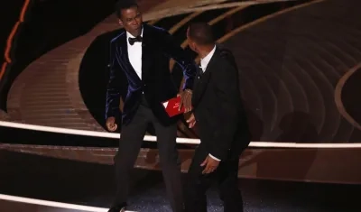  Will Smith (d) mientras abofetea al presentador de la gala Chris Rock (i).