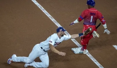 Paul Goldschmidt, de Estados Unidos, intenta poner out en primera base a Roel Santos, de Cuba. 