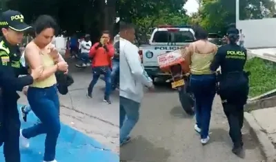 Policías conducen a una mujer luego de robo de un camión de valores cargado de dinero.