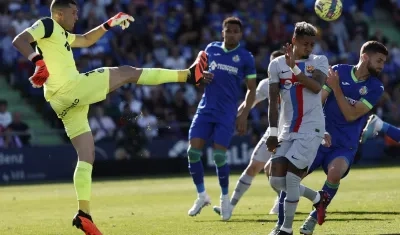 David Soria, portero del Getafe, despeja la pelota ante la llegada de Raphinha.