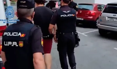 Policías de España conducen a una de las personas capturadas