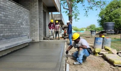 Obreros construyen los andenes en el área de salones y laboratorios.