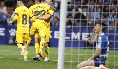 Los jugadores del FC Barcelona Pedri (i), Raphinha y Lewandowski celebran el tercer gol del equipo, ante la mirada del defensa del Espanyol César Montes