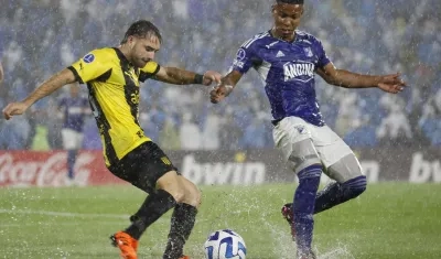Beckham Castro, de Millonarios, intenta impedir el avance de Pedro Milans. 