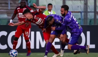 Miguel Monsalve intenta escapar de la marca de dos jugadores rivales 