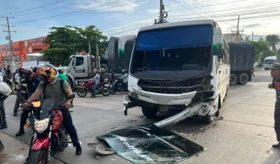 La moto tendida en el suelo y el bus implicados en el accidente.