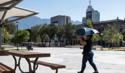 Una mujer sostiene una sombrilla para protegerse del sol, debido a las altas temperaturas en Monterrey, México. 