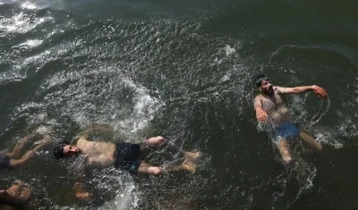 Personas en India se bañan en los ríos por ola de calor.