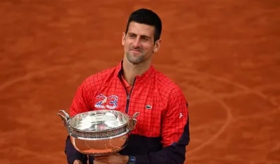 Novak Djokovic besa el trofeo que lo convierte en el más ganador de torneos de Grand Slam. 