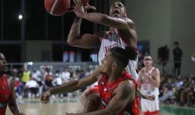 El panameño Ernesto Oglivie intenta encestar ante la presión de un rival.