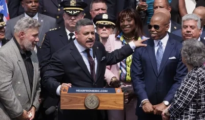 Edward Cabán pone sus manos sobre el hombro del alcalde Eric Adams.