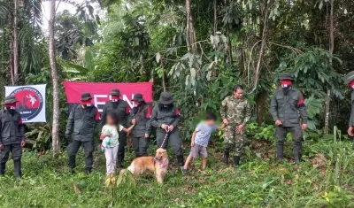 La sargento Karina Ramírez junto a sus dos hijos, su mascota, y guerrilleros del ELN
