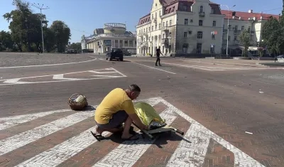  Un hombre junto al cuerpo de una de las víctimas del ataque ruso sobre el centro urbano de la ciudad ucraniana de Chernígov.