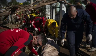 Bomberos retiran el cuerpo de una persona tras las inundaciones. 