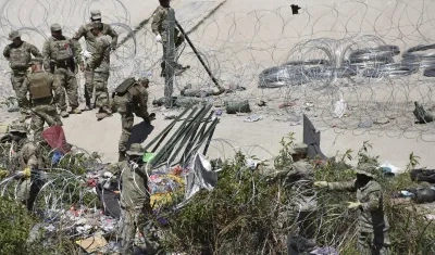 La Guardia Nacional de Estados Unidos retira un campamento de migrantes.