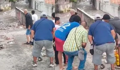 Vecinos viendo como los niños son arrastrados.