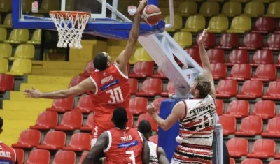 Eloy Vargas, de Titanes, bloquea un lanzamiento de Milos Petrovic. 