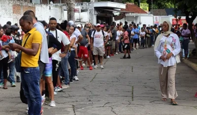Migrantes hacen fila en espera de regularizar su documentación en el municipio de Tapachula, en el estado de Chiapas