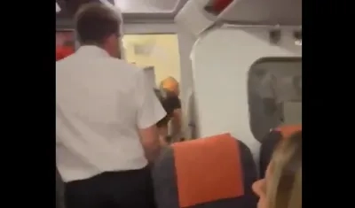 El asistente de vuelo abriendo la puerta del baño del avión.