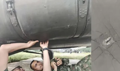 Soldados revisan el helicóptero baleado.