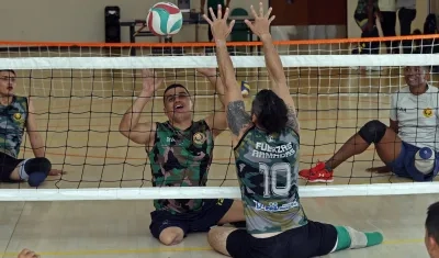El veterano del Ejército Edward Guerrero (2-i) participa en una práctica de voleibol.