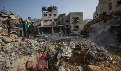 Palestinos buscan entre los escombros de la casa de la familia Al Faseih destruida tras un ataque aéreo.